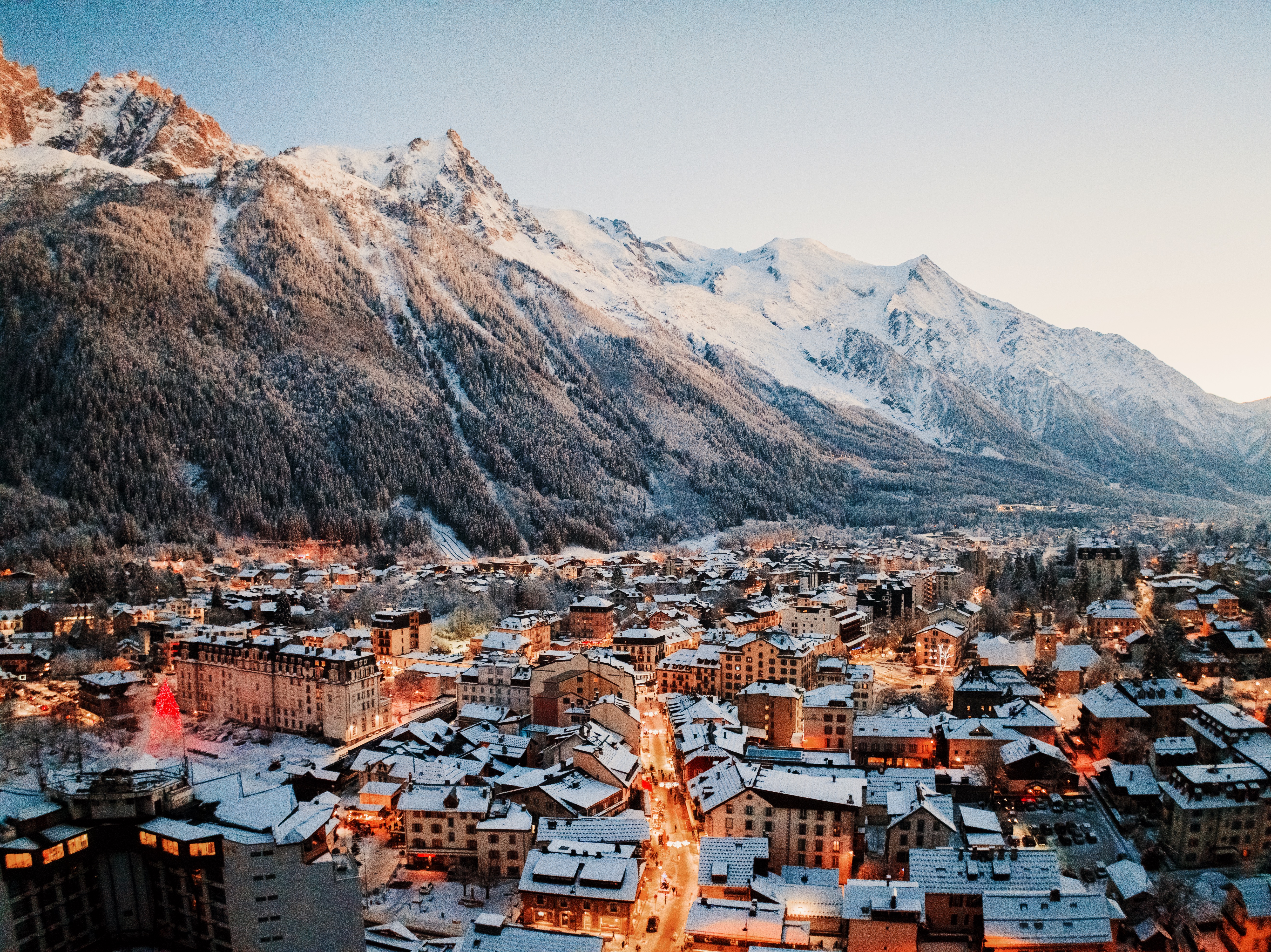 Le centre de Chamonix enneigé et illuminé, sous le massif à la tombée du jour